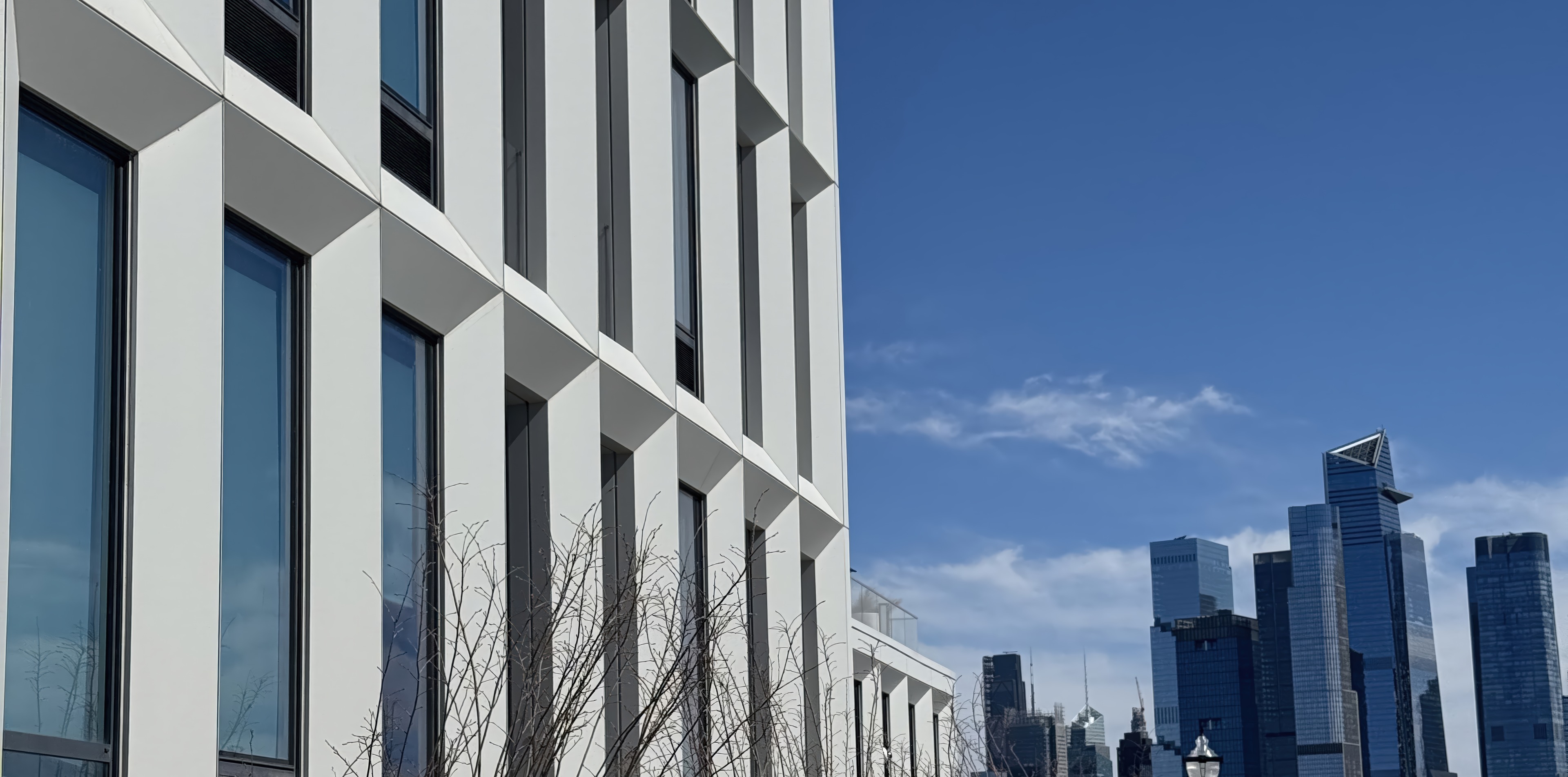 Facciata a pannelli bianchi con lo skyline di Manhattan sullo sfondo